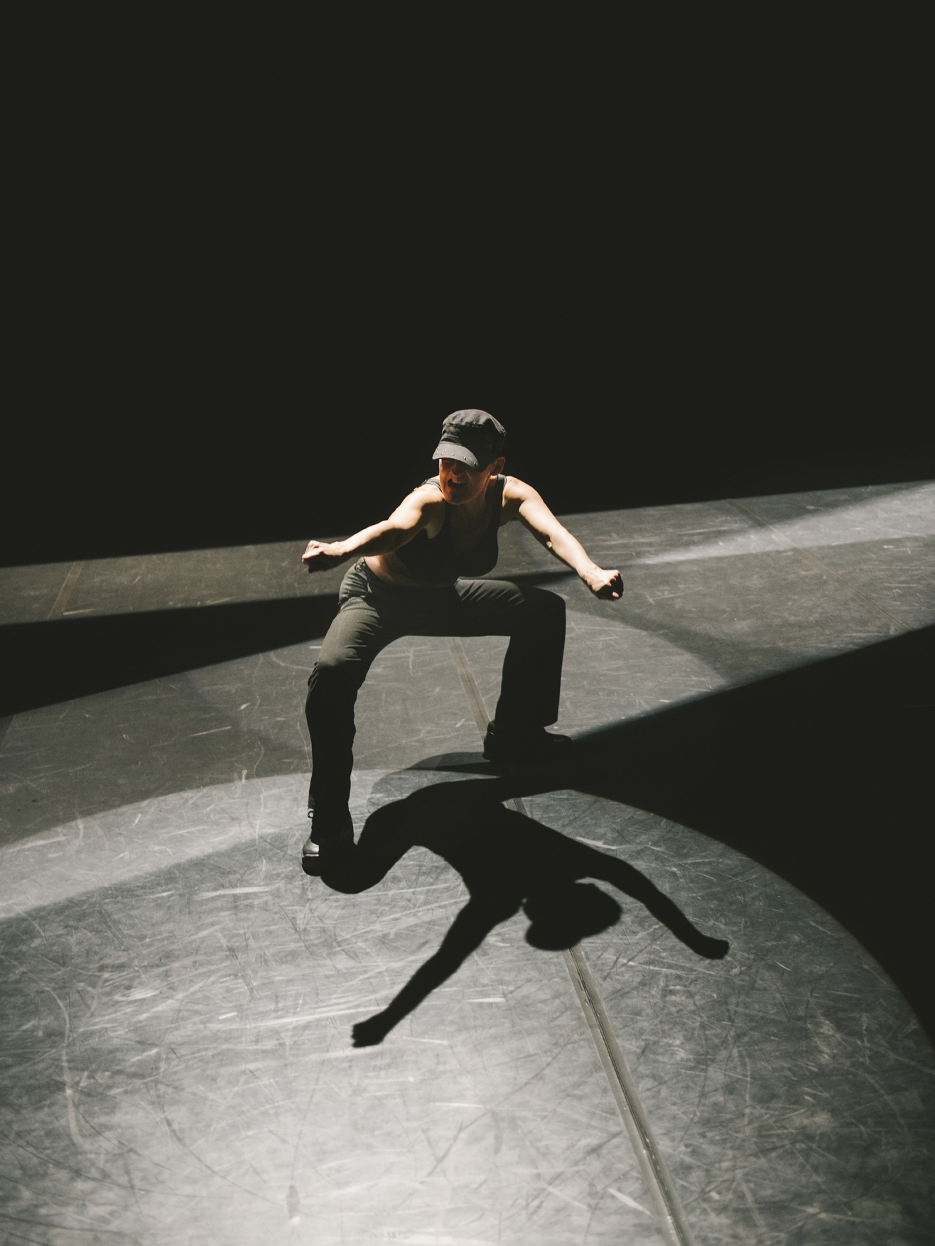 Eine Tänzerin auf dunkler Bühne von schräg oben fotografiert 