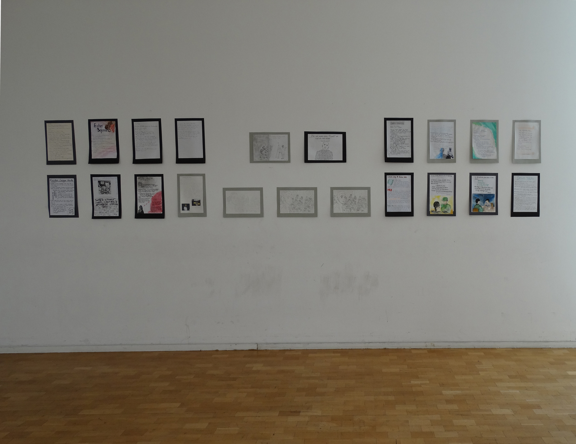 Bilder von Schülerinnen und Schülern hängen in der Ausstellung. 