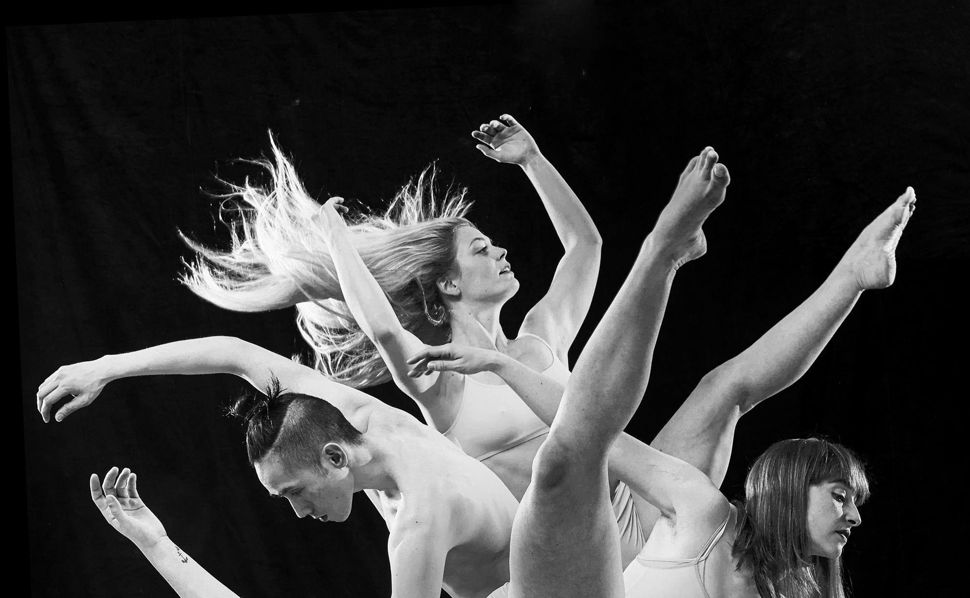 Fotografie von Tänzerinnen und einem Tänzer, hochgestreckte Arme und Beine. Foto: Nik Schölzel