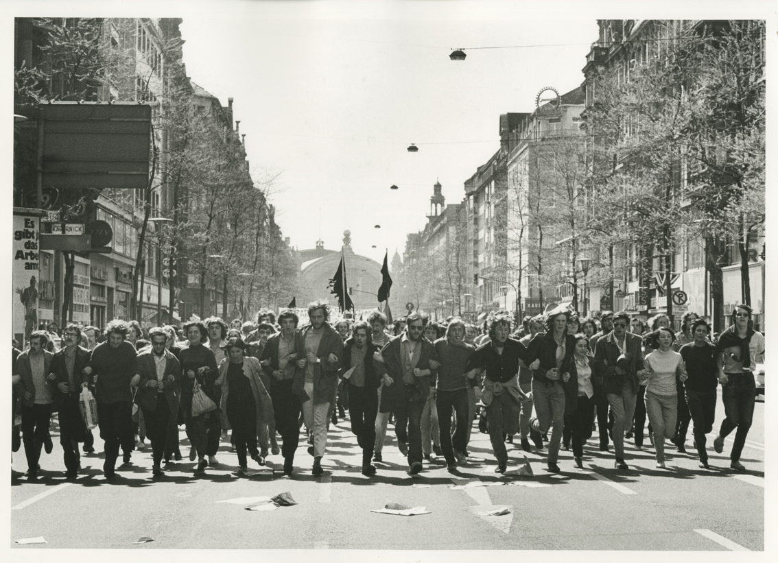 Black and white photography of a street in Frankfurt. A number of demonstrators run towards the photograph. Photo: Barbara Klemm