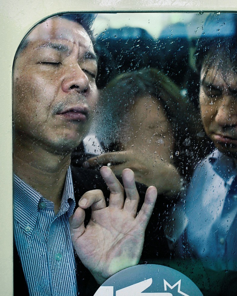 Mann mit Gesicht an Busscheibe gedrückt, dahinter weitere Fahrgäste