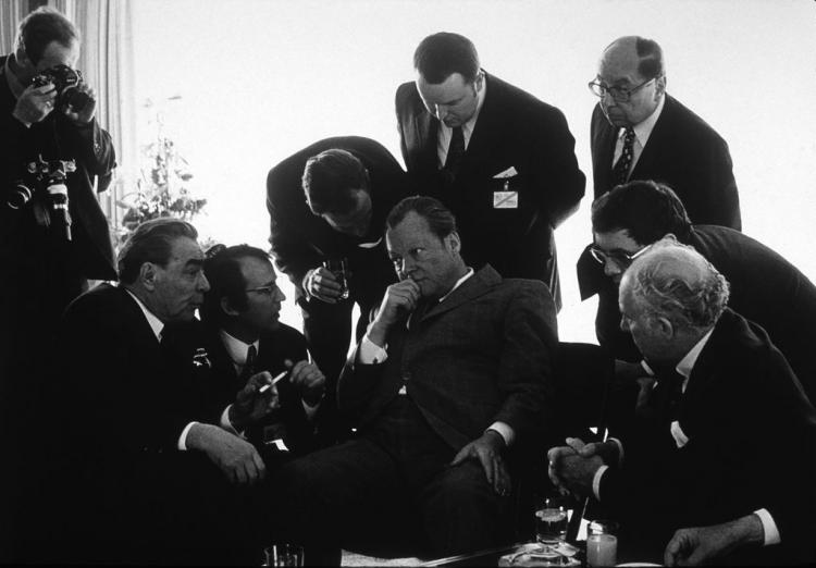 Schwarz-weiß-Bild einer in dunklen Anzügen gekleideten Herren: Politiker und Jornalisten. Gespräch zwischen Leonid Breschnew und Willy Bandt, Bonn, 1973. Foto: Barbara Klemm